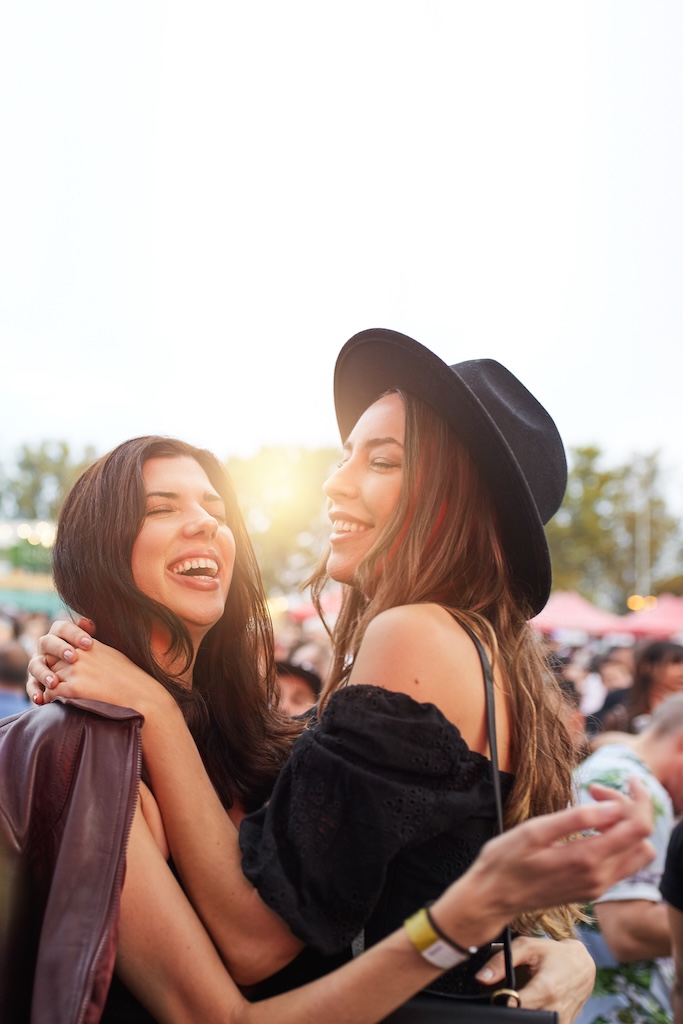 Charming long haired stylish girl friends having fun in bright day at alumni event after IOP.