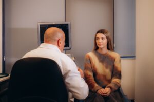 Male psychiatrist talking with female client regarding somatic therapy and overall treatment plan for outpatient treatment.