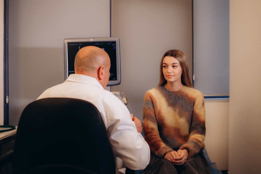 Male psychiatrist talking with female client regarding somatic therapy and overall treatment plan for outpatient treatment.
