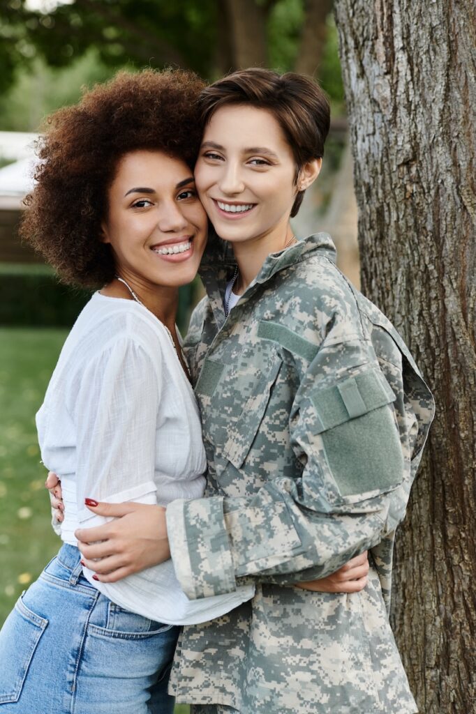 A female soldier in camouflage embraces her wife joyfully