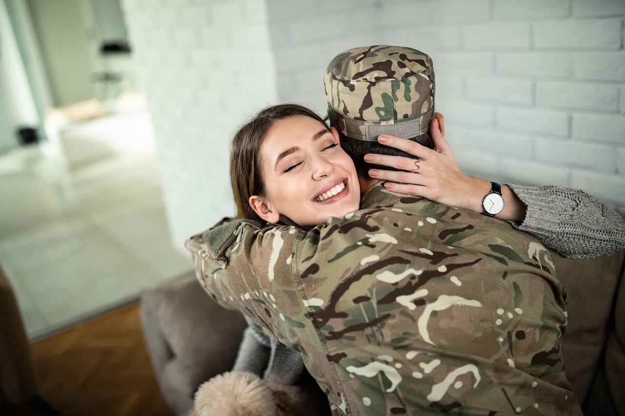 High angle view of happy woman embracing he military husband at home.