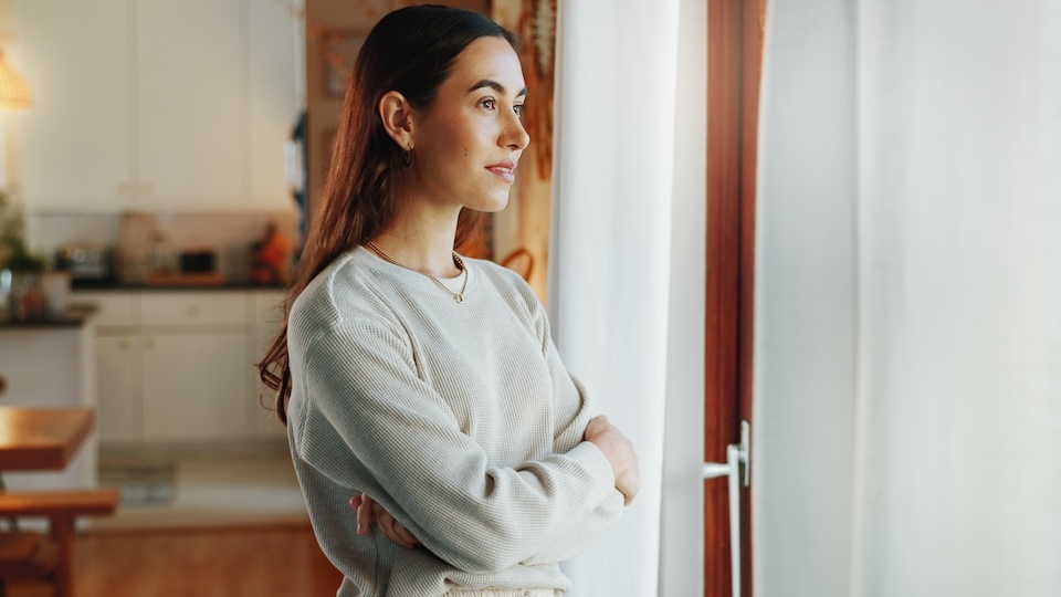 Girl, arms crossed and thinking by window in home with daydreaming, reflection