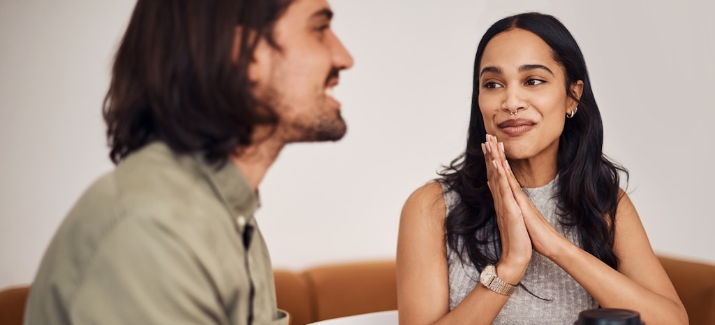 Couple sitting and talking at coffee table.
