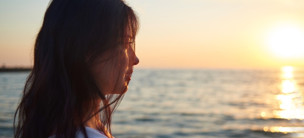 Portrait of girl looking on beatiful sea sunset.