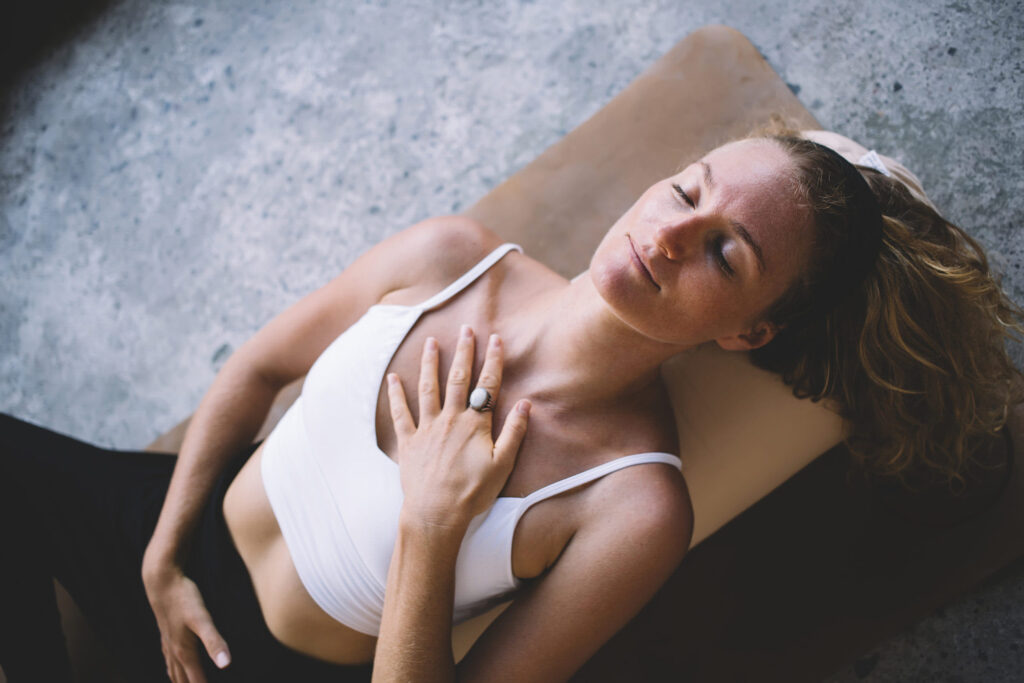 young female with closed eyes lying on mat