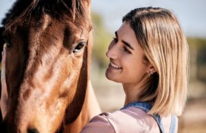 Face, smile for equestrian and a woman with her horse on a ranch