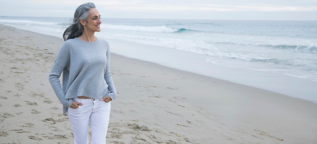 Woman enjoying a peaceful walk on a cloudy beach day