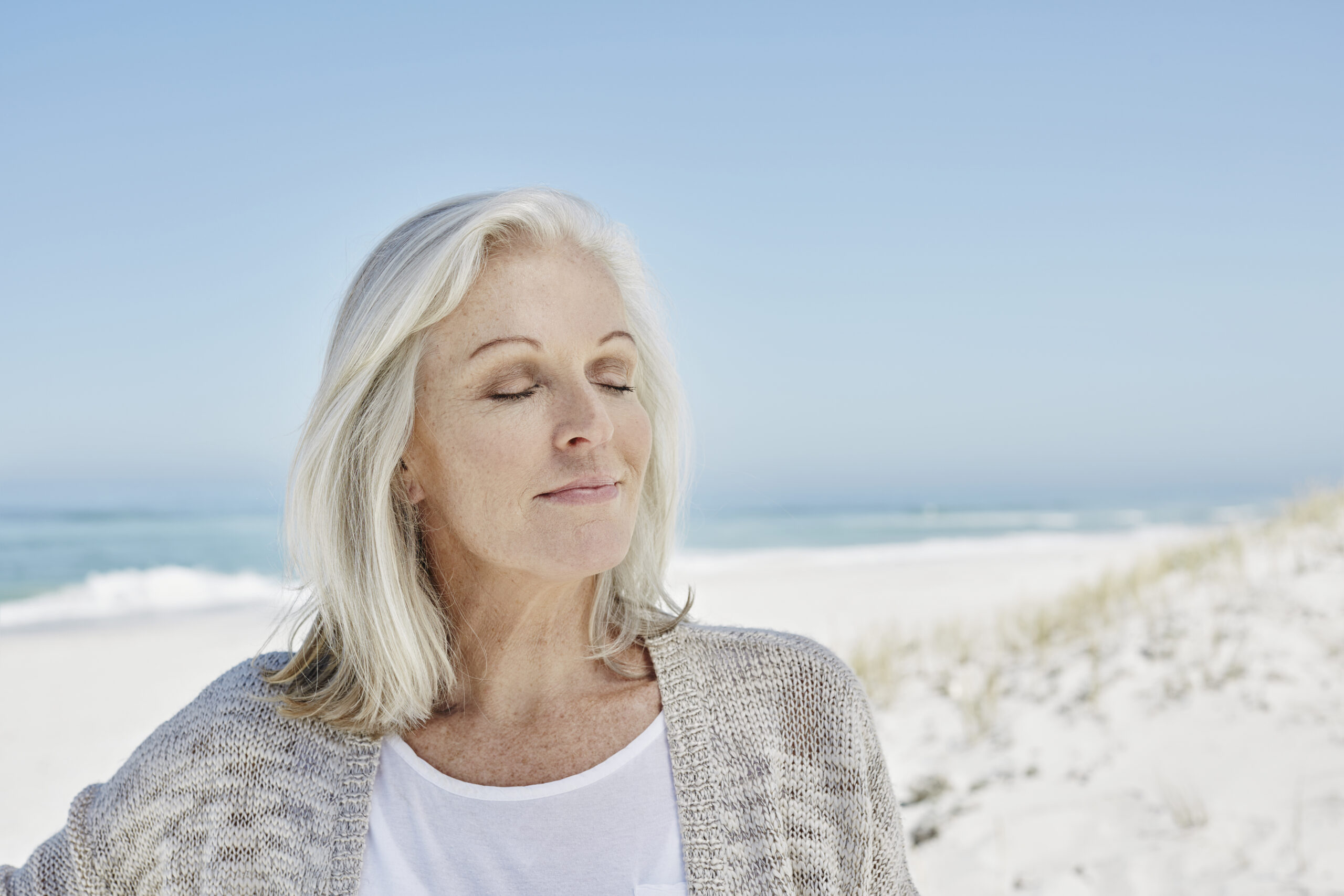 Mature woman at the beach, eyes closed