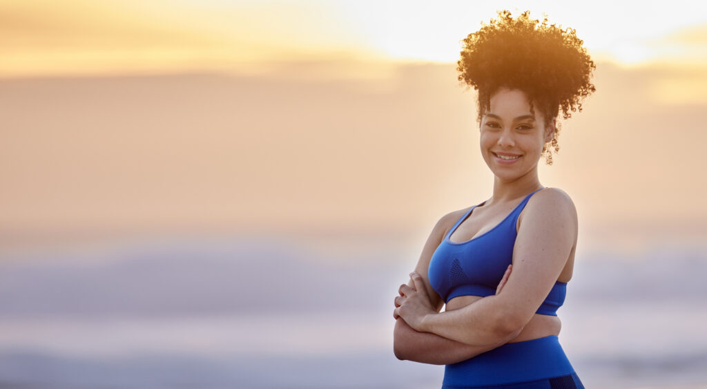 Shot of a young female doing yoga on the beach