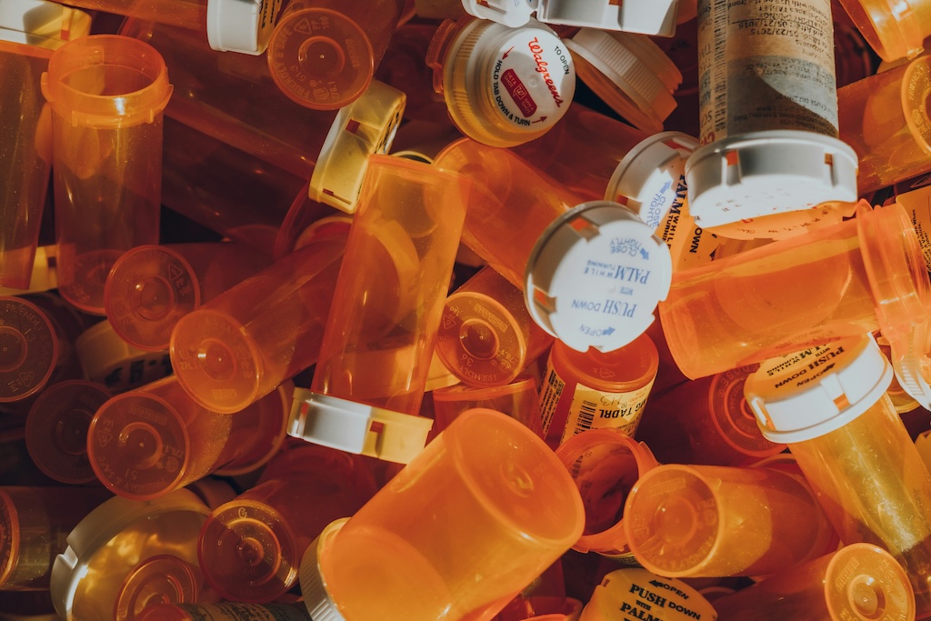Orange prescription pill bottles in a pile on top of each other