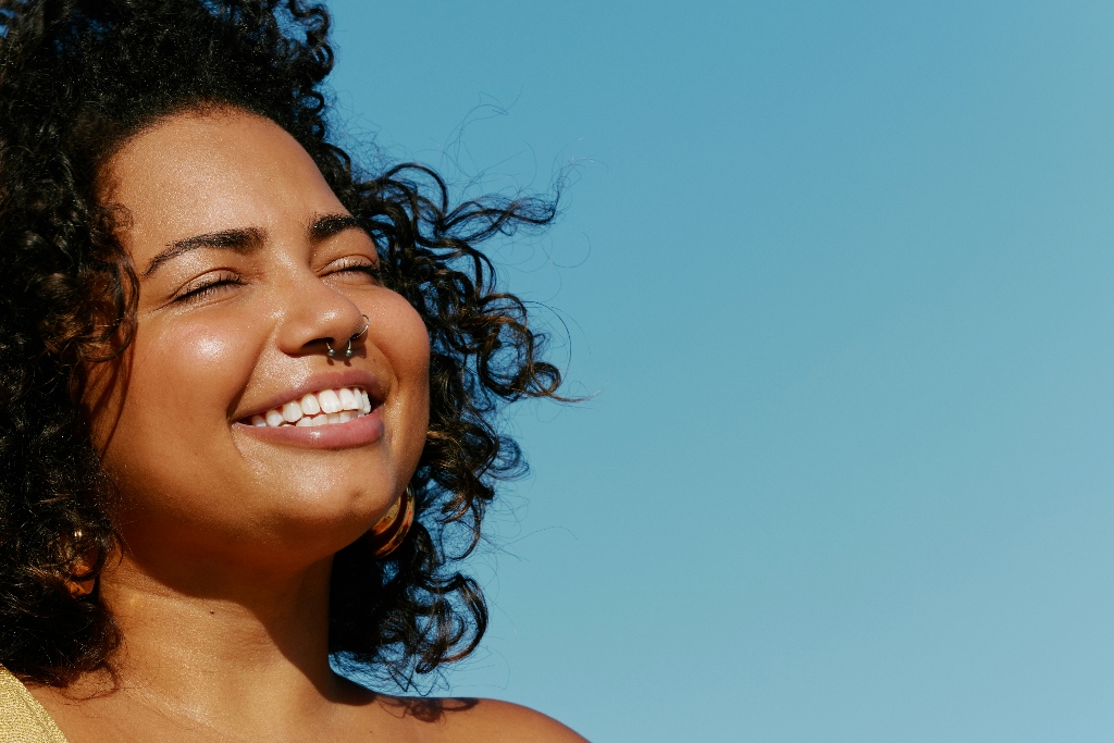 Woman smiling with eyes closed in natural sunlight, representing hope, emotional healing, and recovery from benzodiazepine dependence.