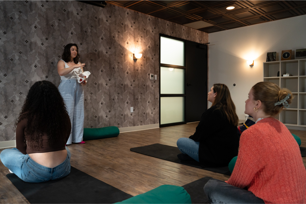 Dr. Rose Schlaff leading a pelvic floor therapy group and demonstrating pelvic anatomy for clients at Monima Wellness Center.