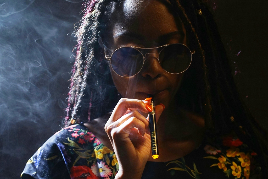 Woman vaping cannabis, illustrating the Cali sober approach to recovery.